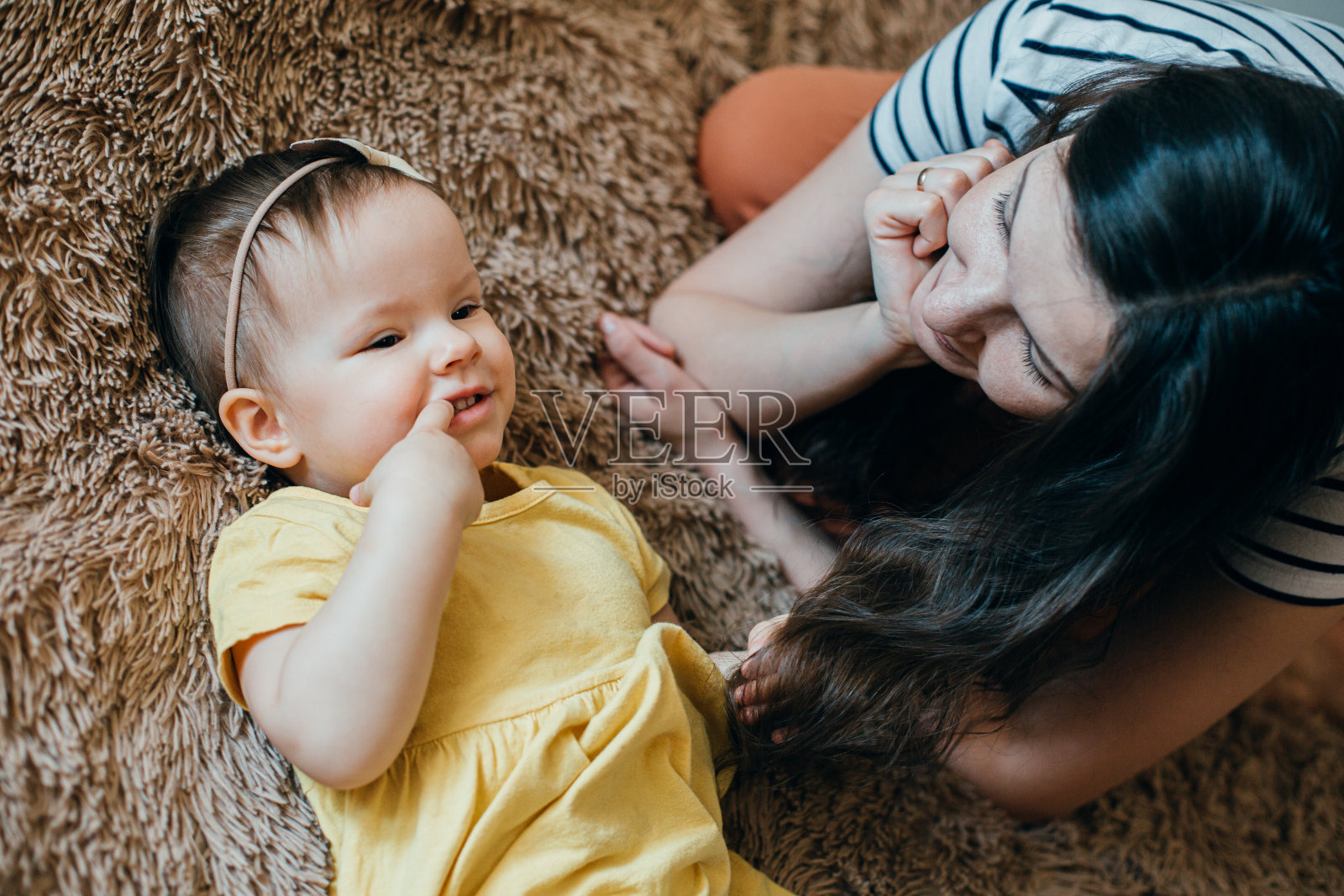 爱做梦的女孩躺在床上，把手指放进嘴里照片摄影图片