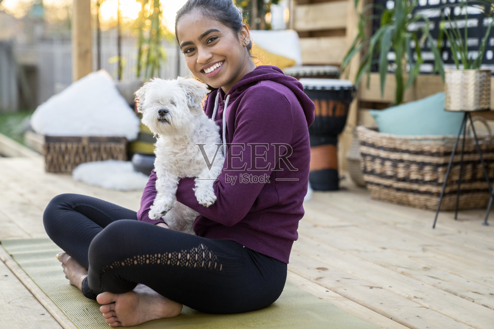 中东女子和狗坐在瑜伽垫上照片摄影图片
