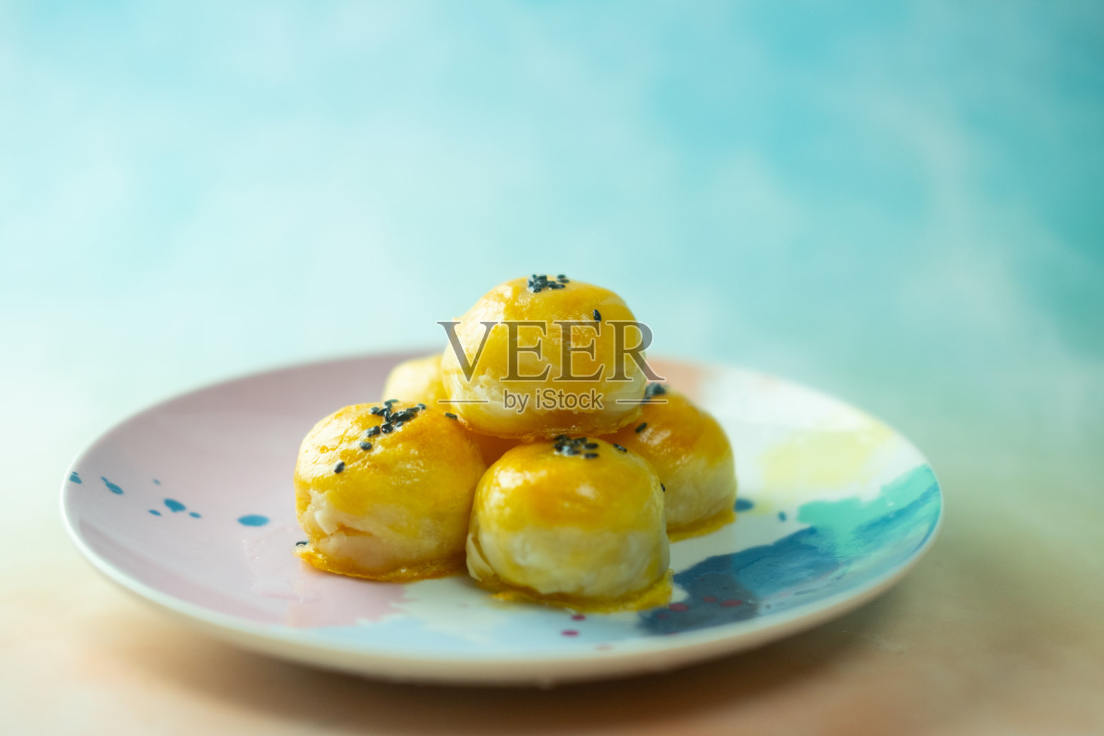 一种中式糕点或月饼，上面有绿豆沙和咸蛋黄，再加上黑芝麻照片摄影图片