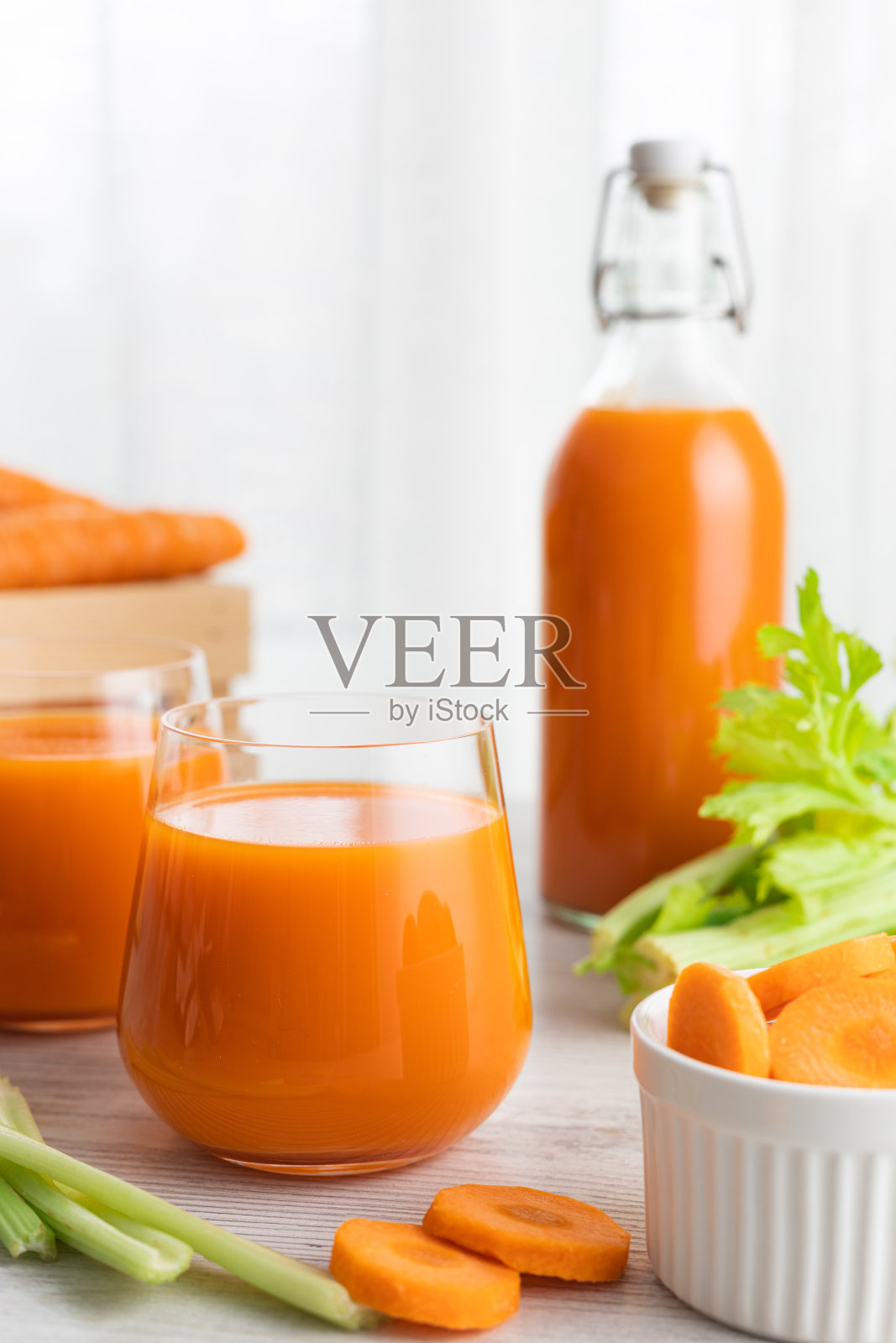杯子里有胡萝卜汁和芹菜。照片摄影图片