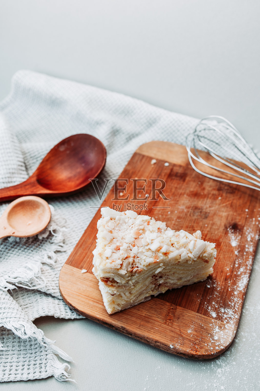 漂亮的煎饼放在一个木架子上，放在厨房的灯桌上，还有一个打蛋器，木勺子和一条华夫饼毛巾。自制的美丽的早餐照片摄影图片