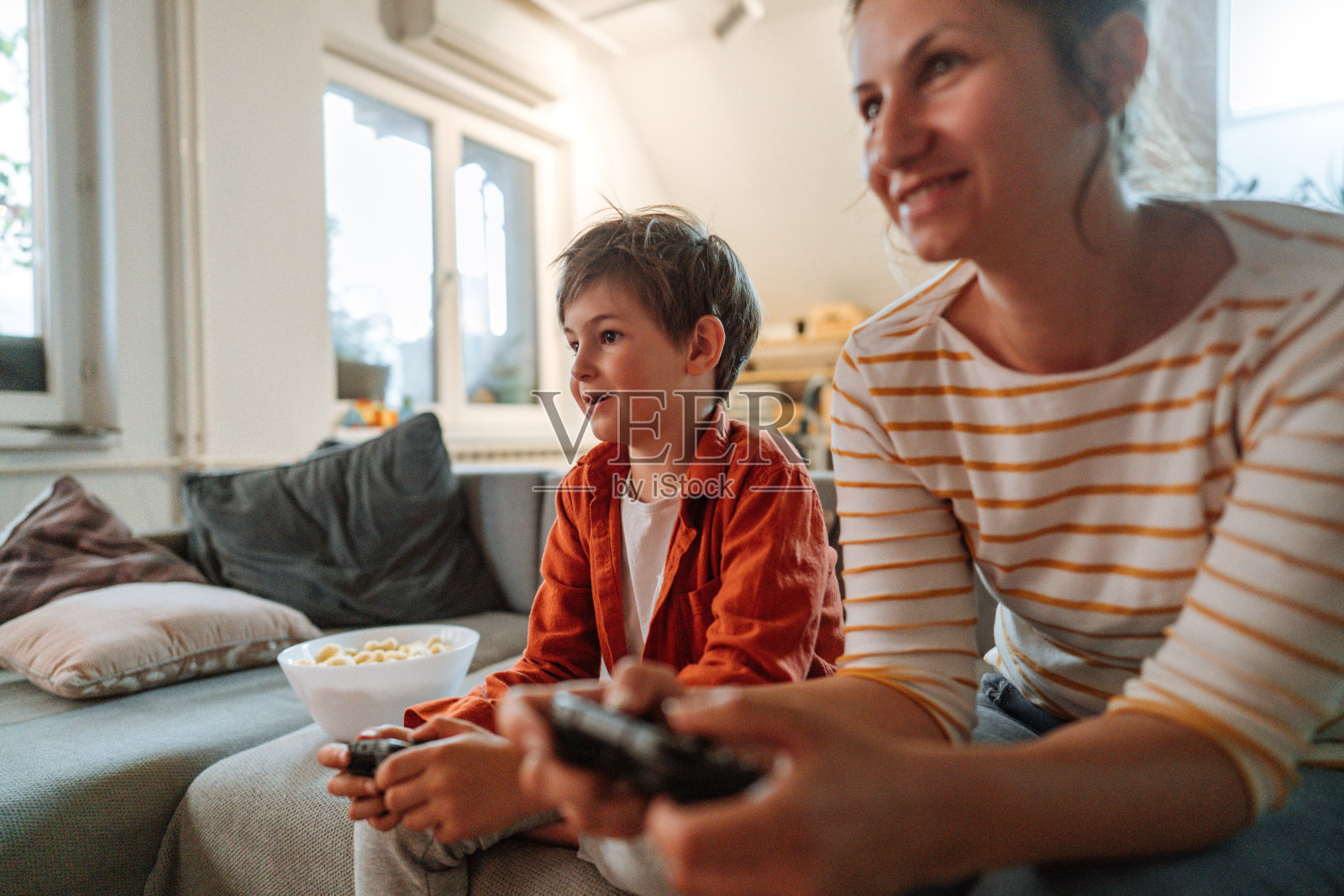 妈妈和儿子在家里玩电子游戏照片摄影图片