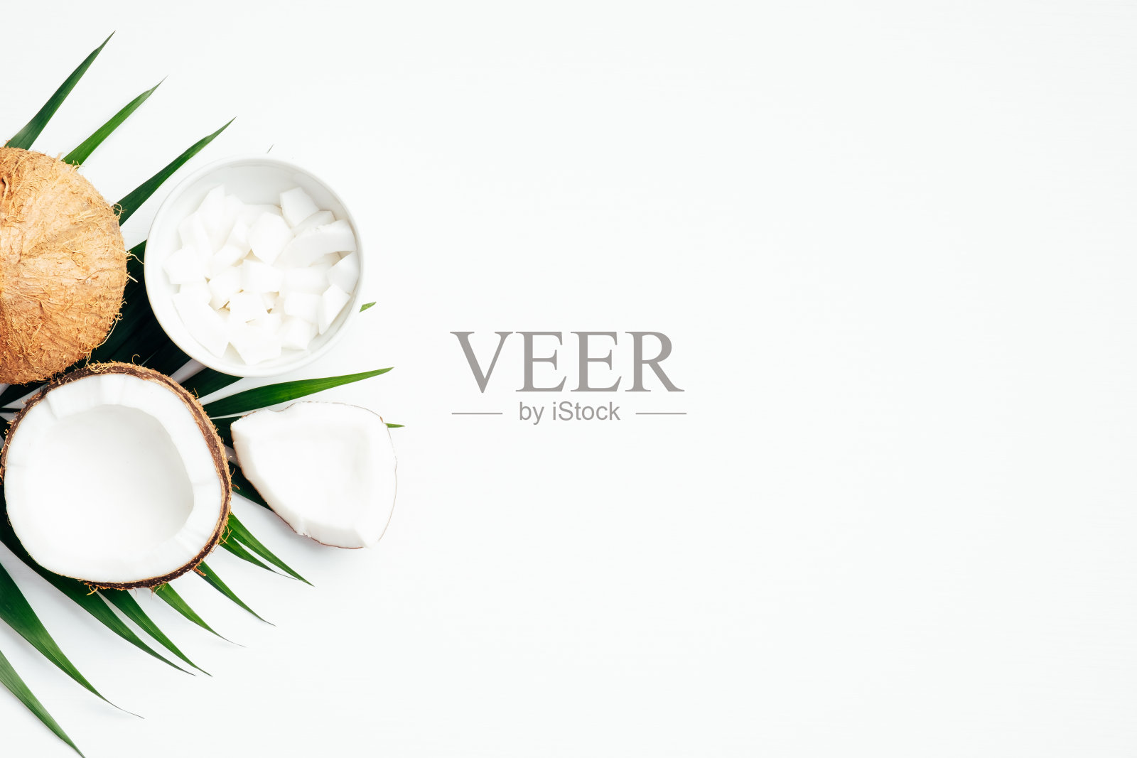 夏季背景与椰子果和棕榈叶在白色的背景。平铺，俯视图，拷贝空间照片摄影图片