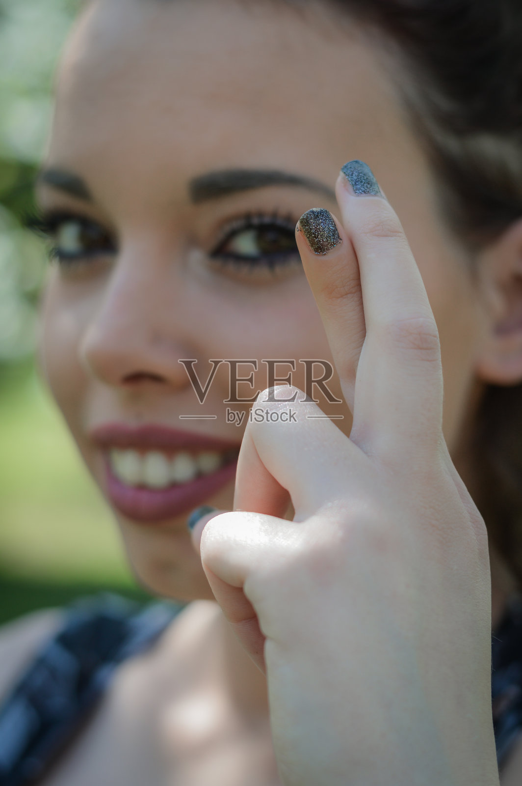 祈祷。年轻女子交叉手指祈求好运。快乐的女孩给予满足和支持的手势。注意手指。照片摄影图片