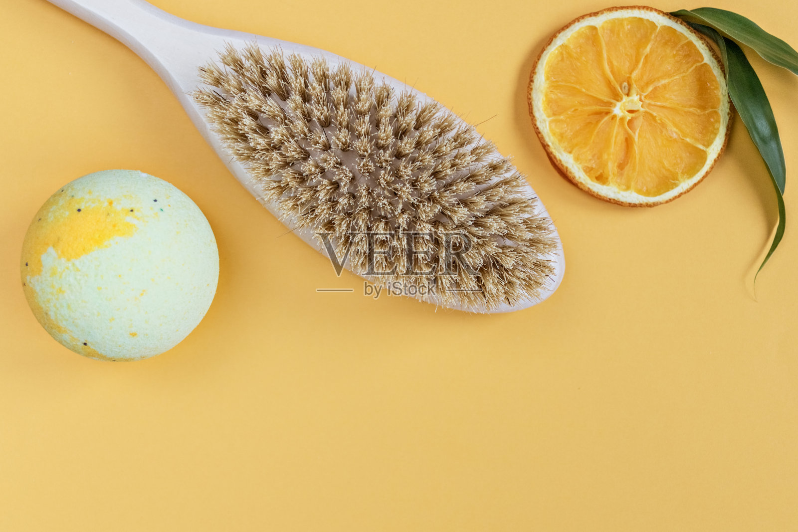 橙色的背景上是护理产品:沐浴露和炸弹。香薰:橘片。家庭水疗的概念。照片摄影图片