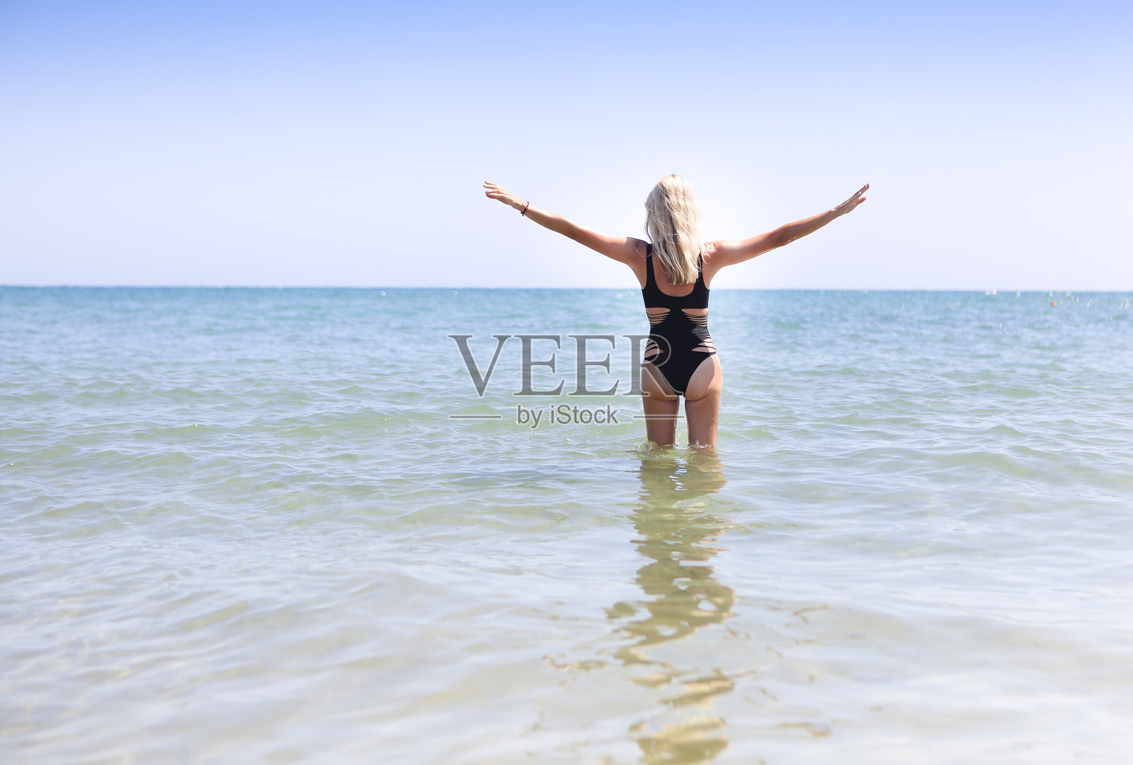 海滩上穿着黑色泳衣的女人照片摄影图片