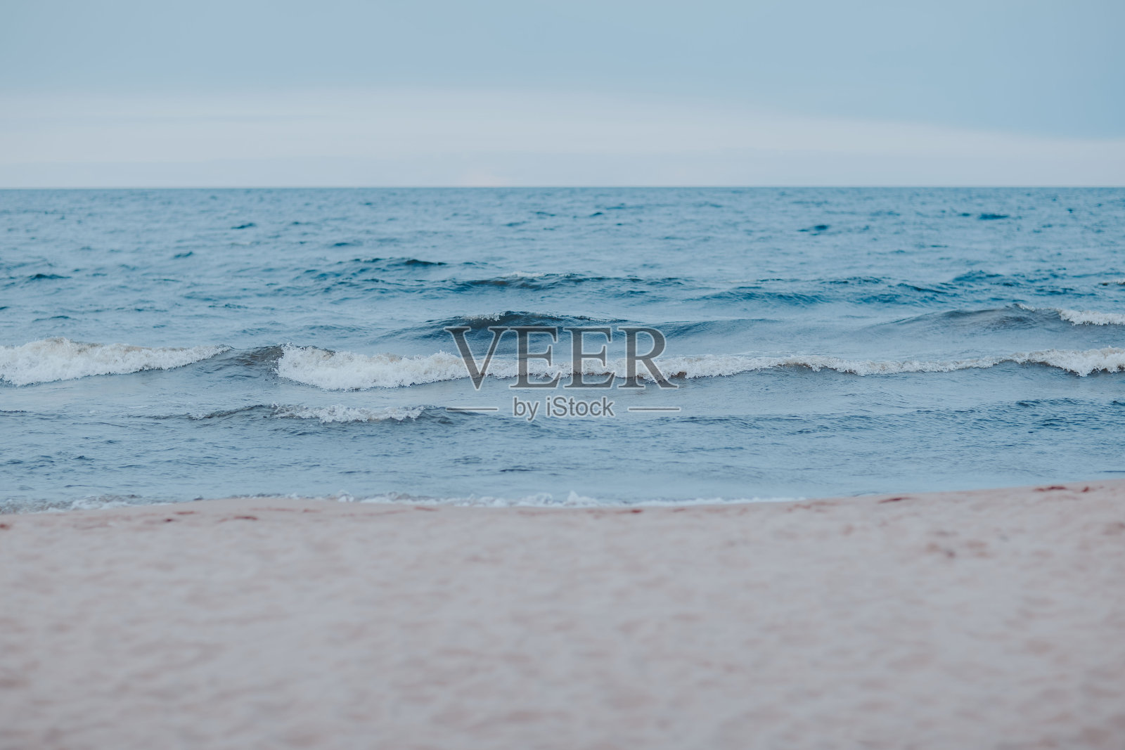 海水湛蓝的海岸。湖面上有暴风雨天气。恶劣天气下有海浪的沙滩。北海有风。照片摄影图片