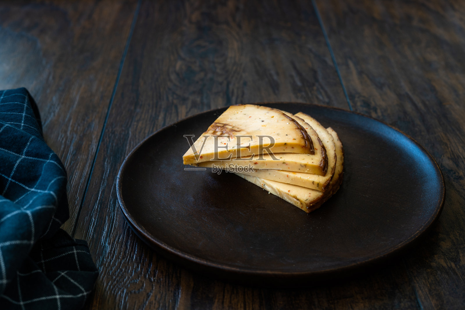 切尔卡斯三角烟熏奶酪片配香料。照片摄影图片