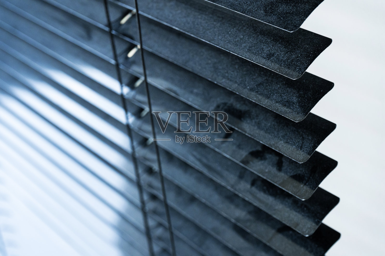 窗户被灰尘遮住了。房子里的吸尘器。需要湿洗。百叶窗上有一层灰尘。照片摄影图片