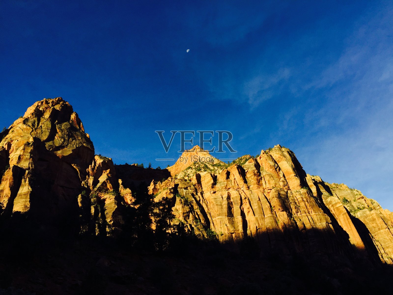 山峰矗立在阴影之上，触摸天空照片摄影图片