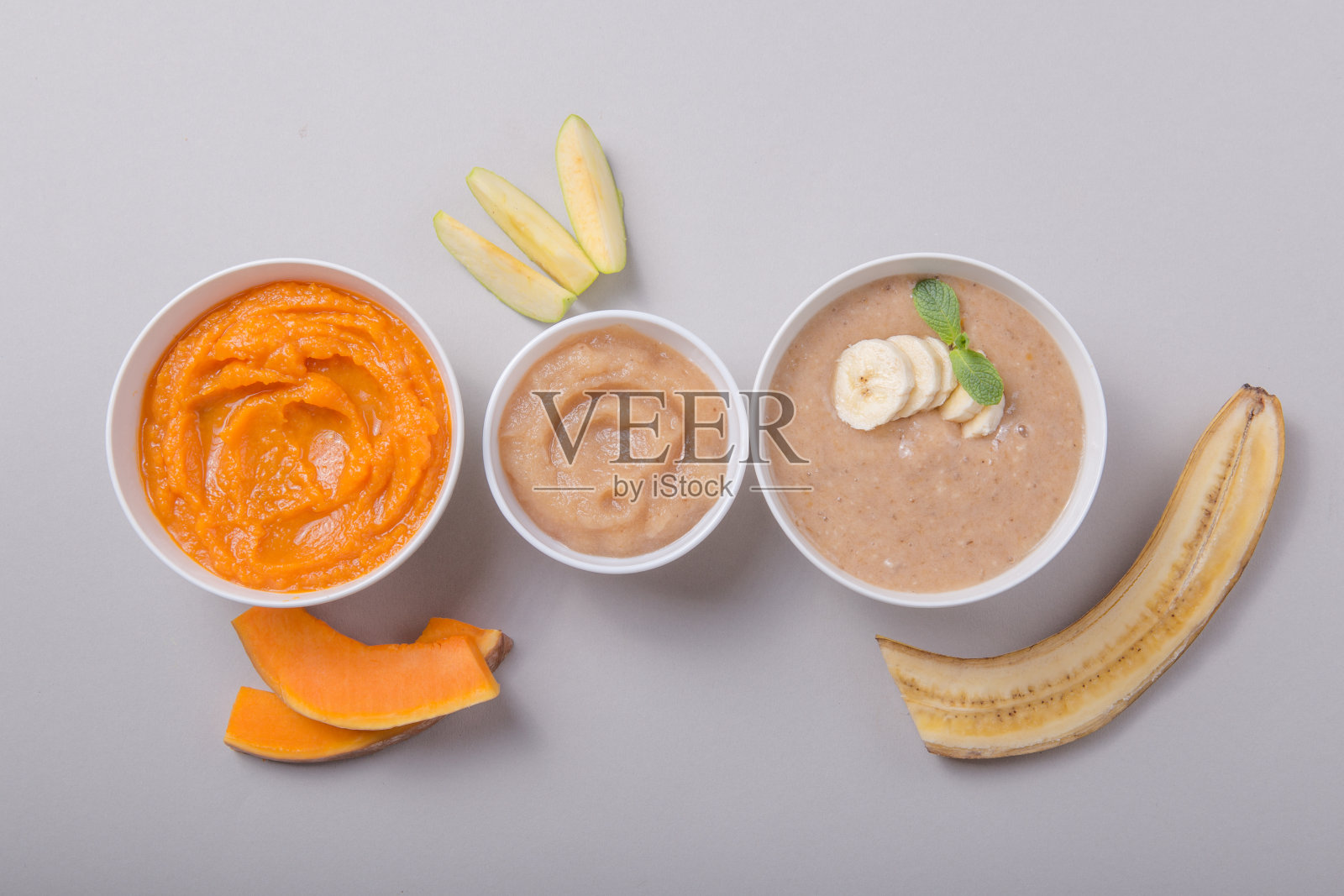 颜色背景上有健康婴儿食品的碗。果泥，由新鲜的有机水果和蔬菜，剥皮，俯视图，概念。孩子们吃饭照片摄影图片