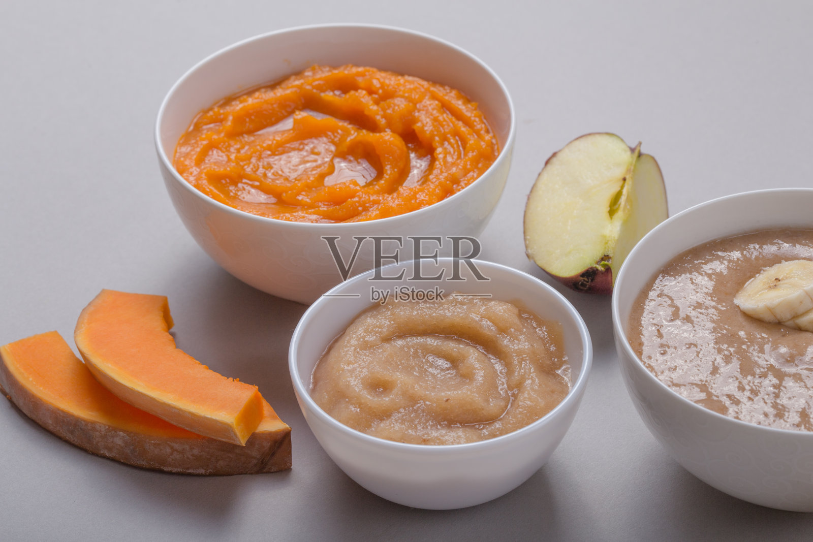 颜色背景上有健康婴儿食品的碗。果泥，由新鲜的有机水果和蔬菜，剥皮，俯视图，概念。孩子们吃饭照片摄影图片