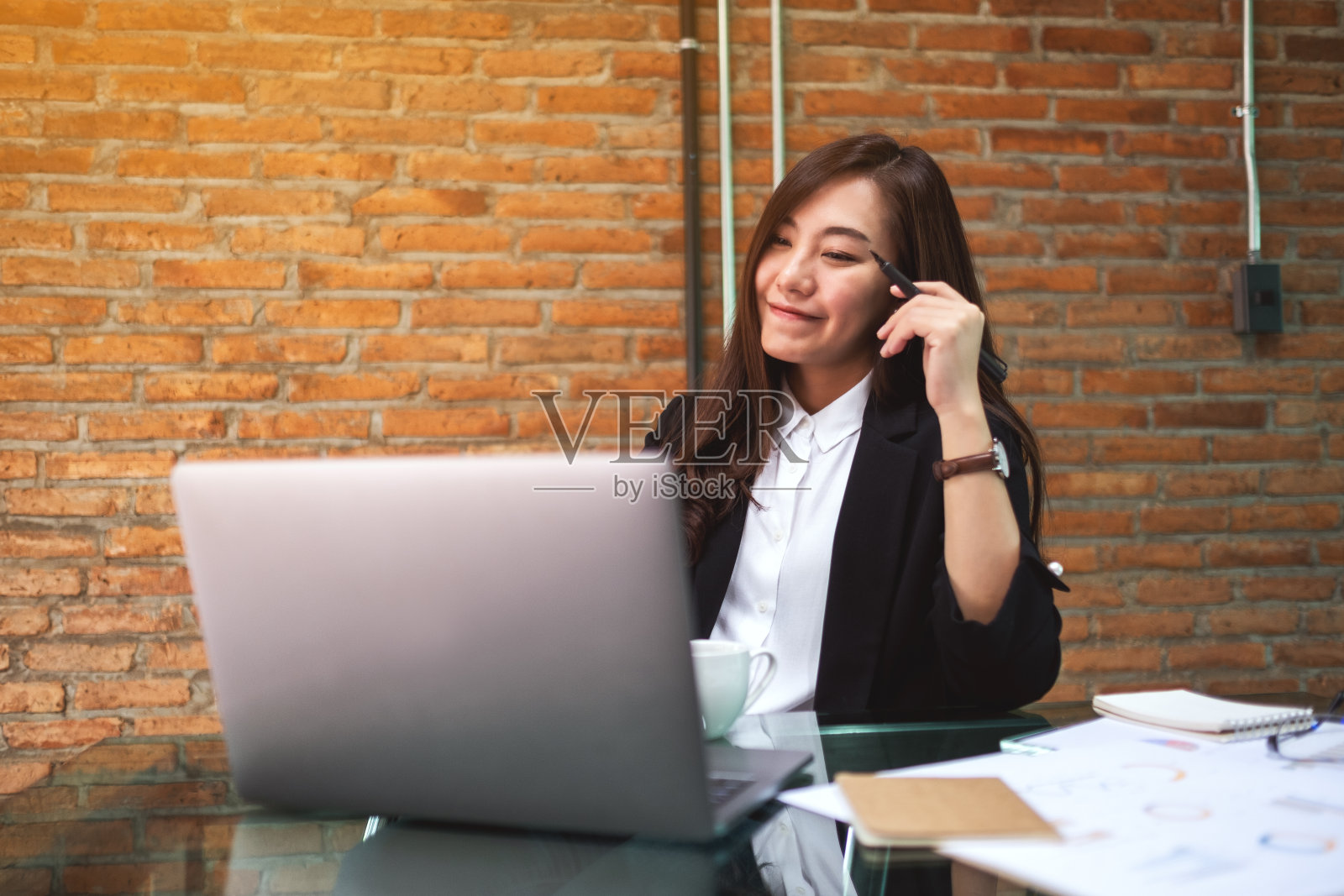 一位美丽的亚洲女商人在办公室工作时使用笔记本电脑打字照片摄影图片