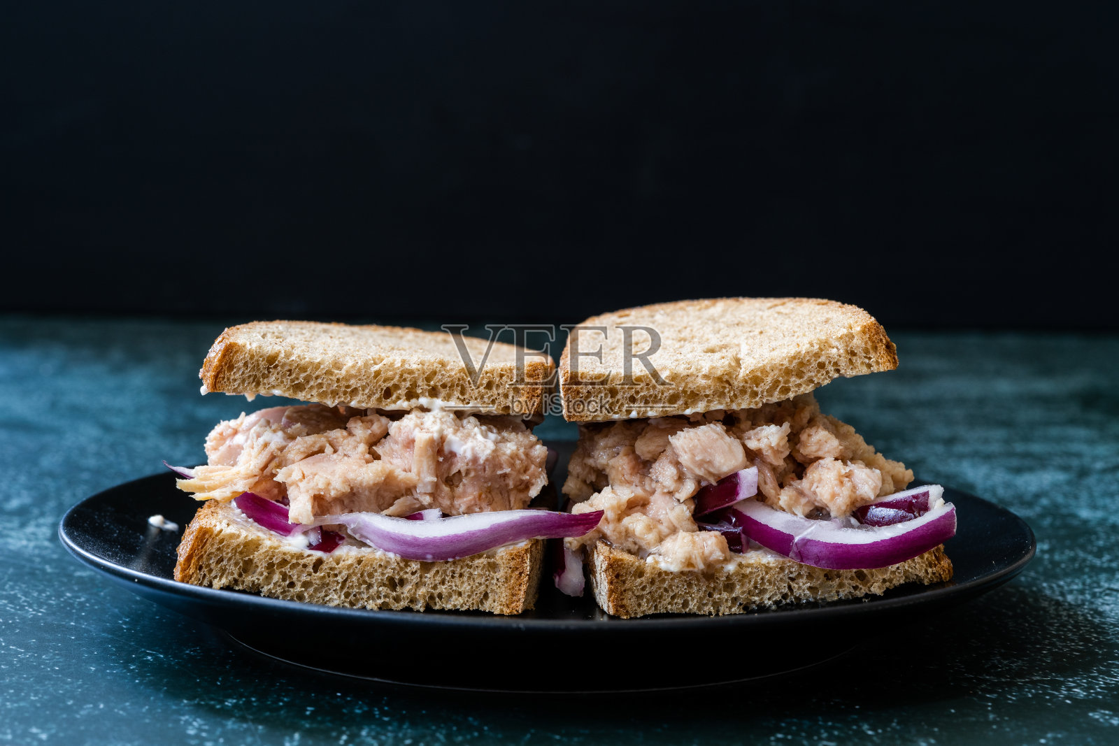 金枪鱼三明治配红洋葱，蛋黄酱和杂粮轻吐司面包。照片摄影图片