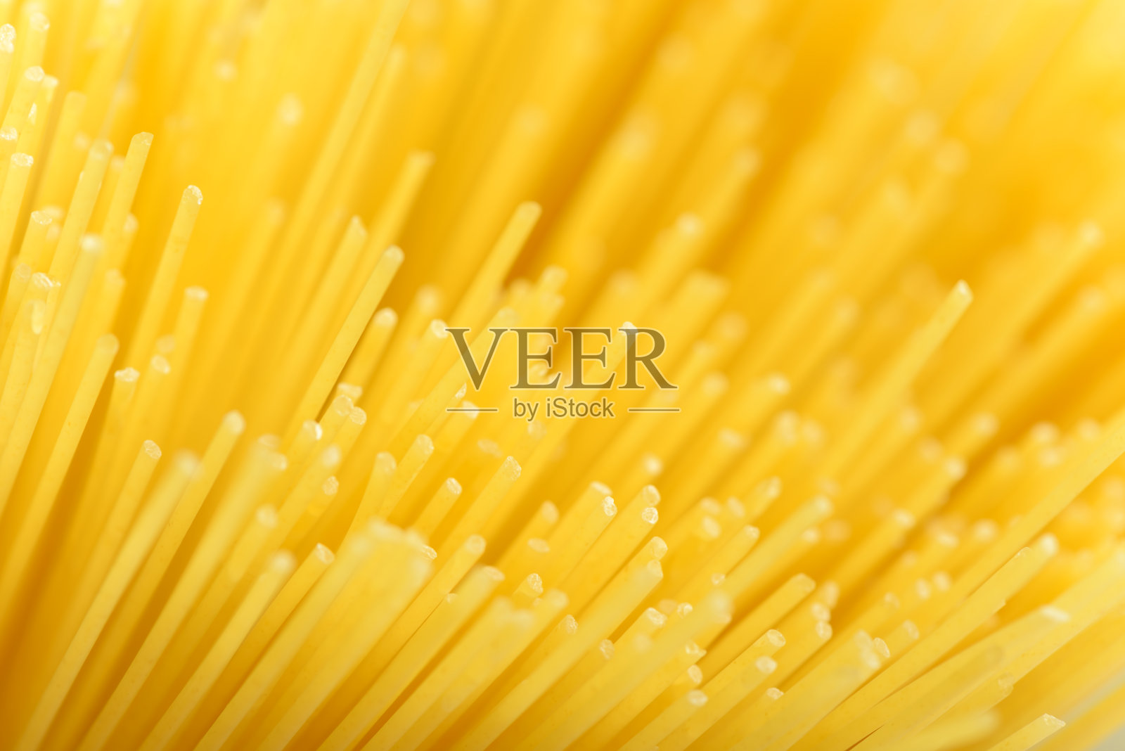 长长的黄色意粉是意大利面食的配料。生干通心粉。薄生面条。谷物小麦产品美味的美食烹饪。是碳水化合物的有用来源。健康的意大利面食。照片摄影图片