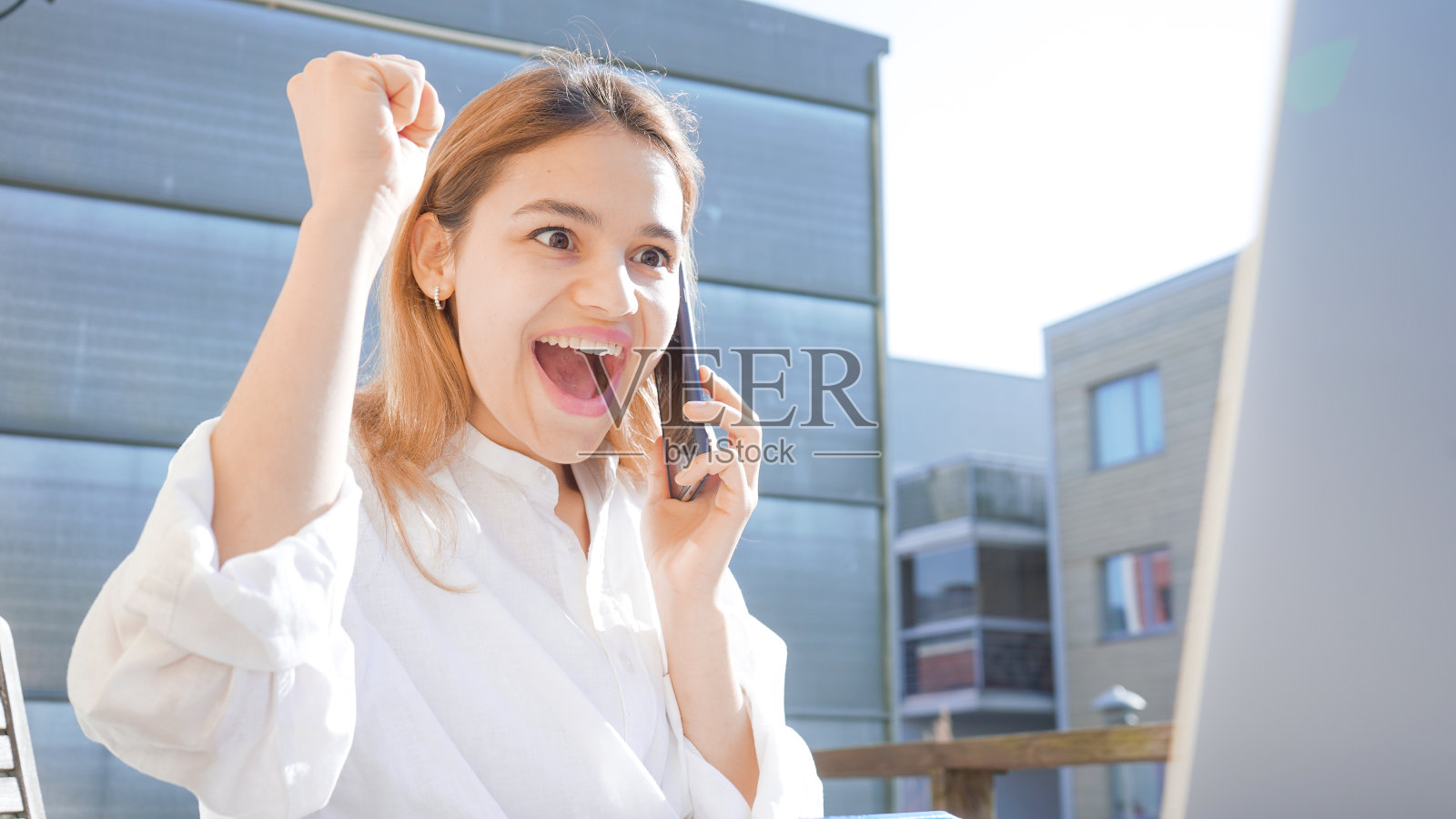 自信的商务女士在打电话，快乐微笑的女孩在阳光明媚的日子里在阳台上在家工作，使用电脑和电话照片摄影图片