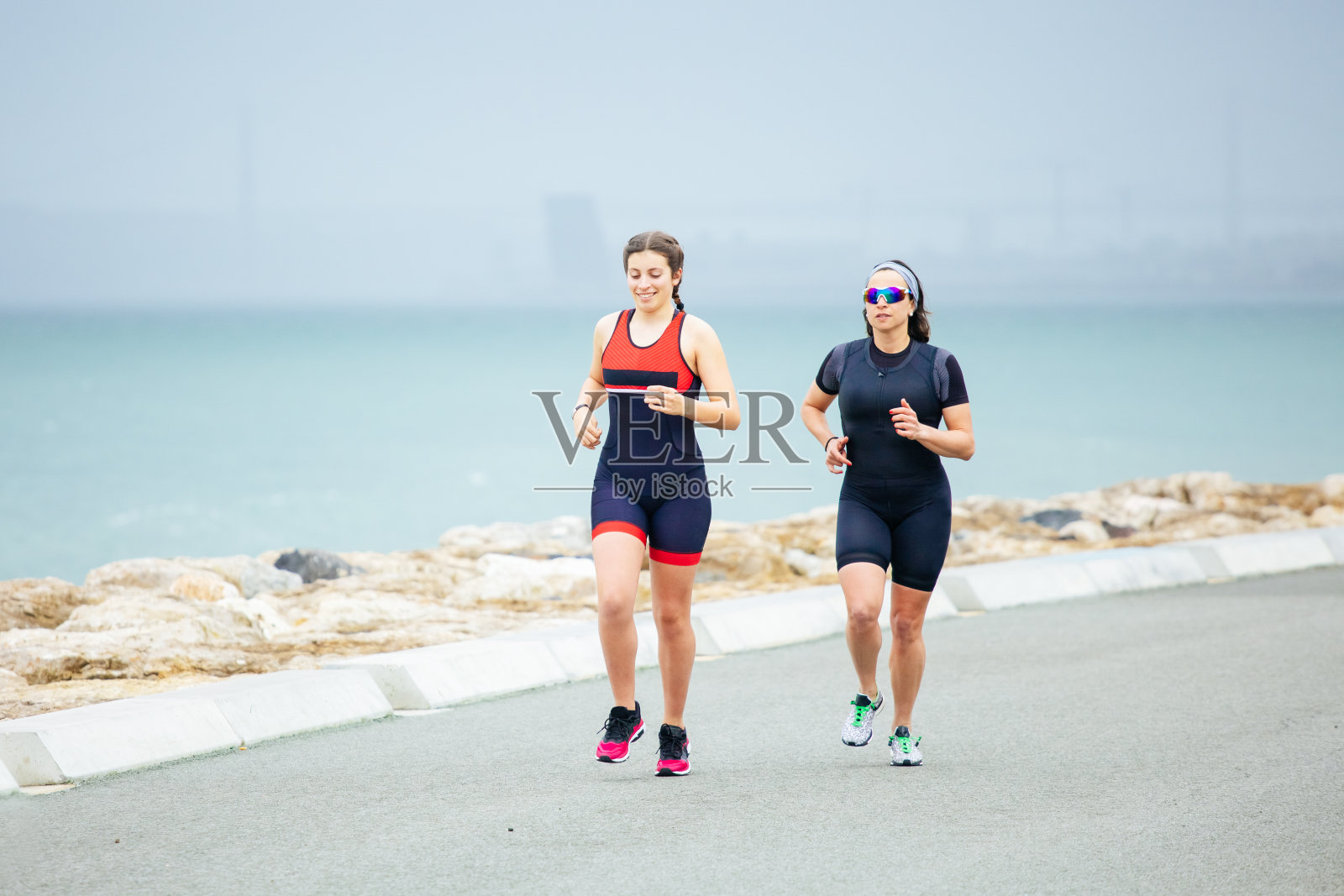 在海边跑步的运动女性照片摄影图片