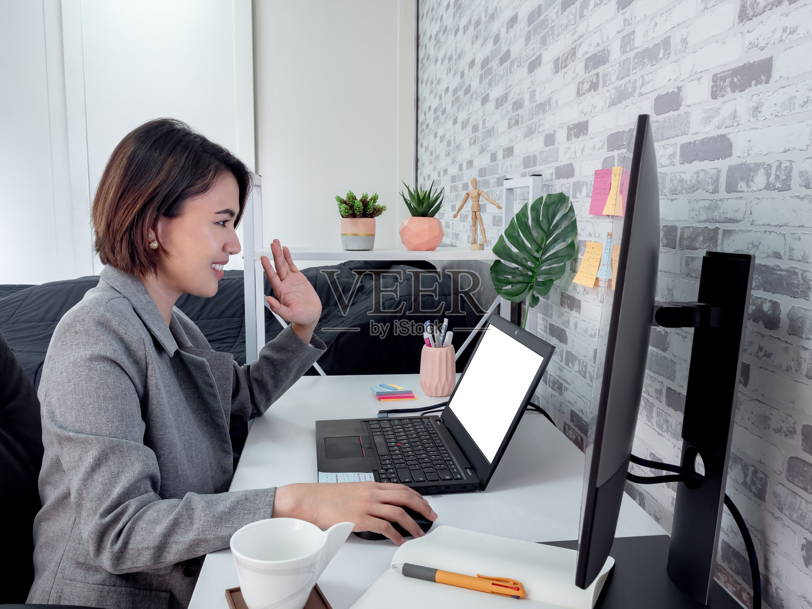 美丽快乐的亚洲女人与笔记本电脑在她的房间，公寓。照片摄影图片