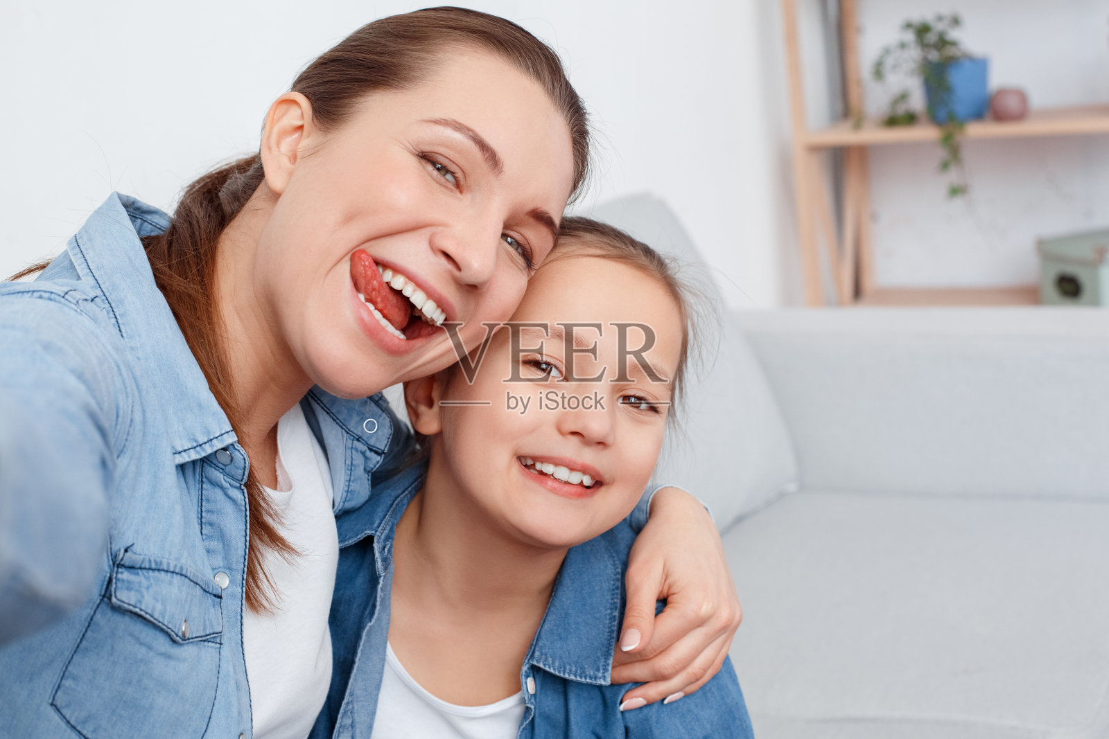 快乐快乐的人们年轻的女人宝宝一起看着手机拍照。捕捉瞬间享受乐趣。一对夫妇收养了一个孤儿，用爱抚养她。关心可爱，漂亮，有魅力的女士照片摄影图片