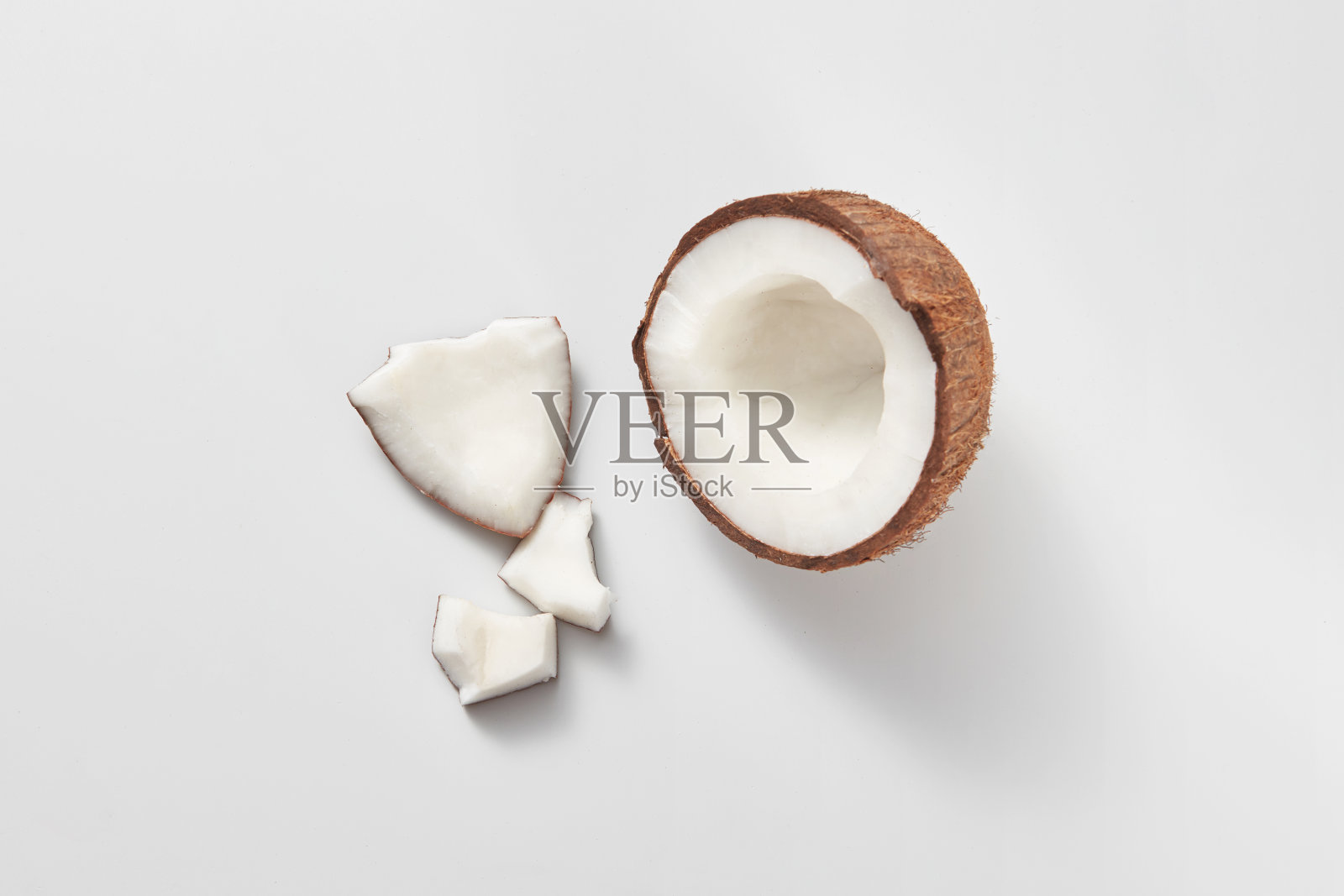 俯视图新鲜的天然有机椰子的一半在浅灰色的背景。照片摄影图片