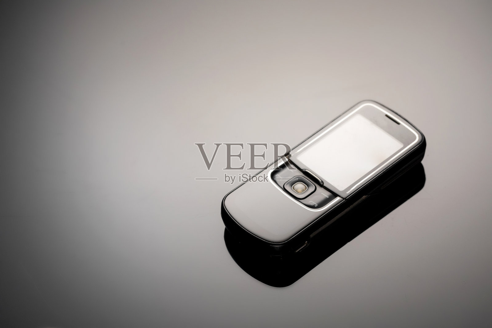 一个过时的手机，带有一个用于在灰色渐变背景上复制空间的屏幕。极简主义的趋势。智能手机。与复制空间的文本照片摄影图片