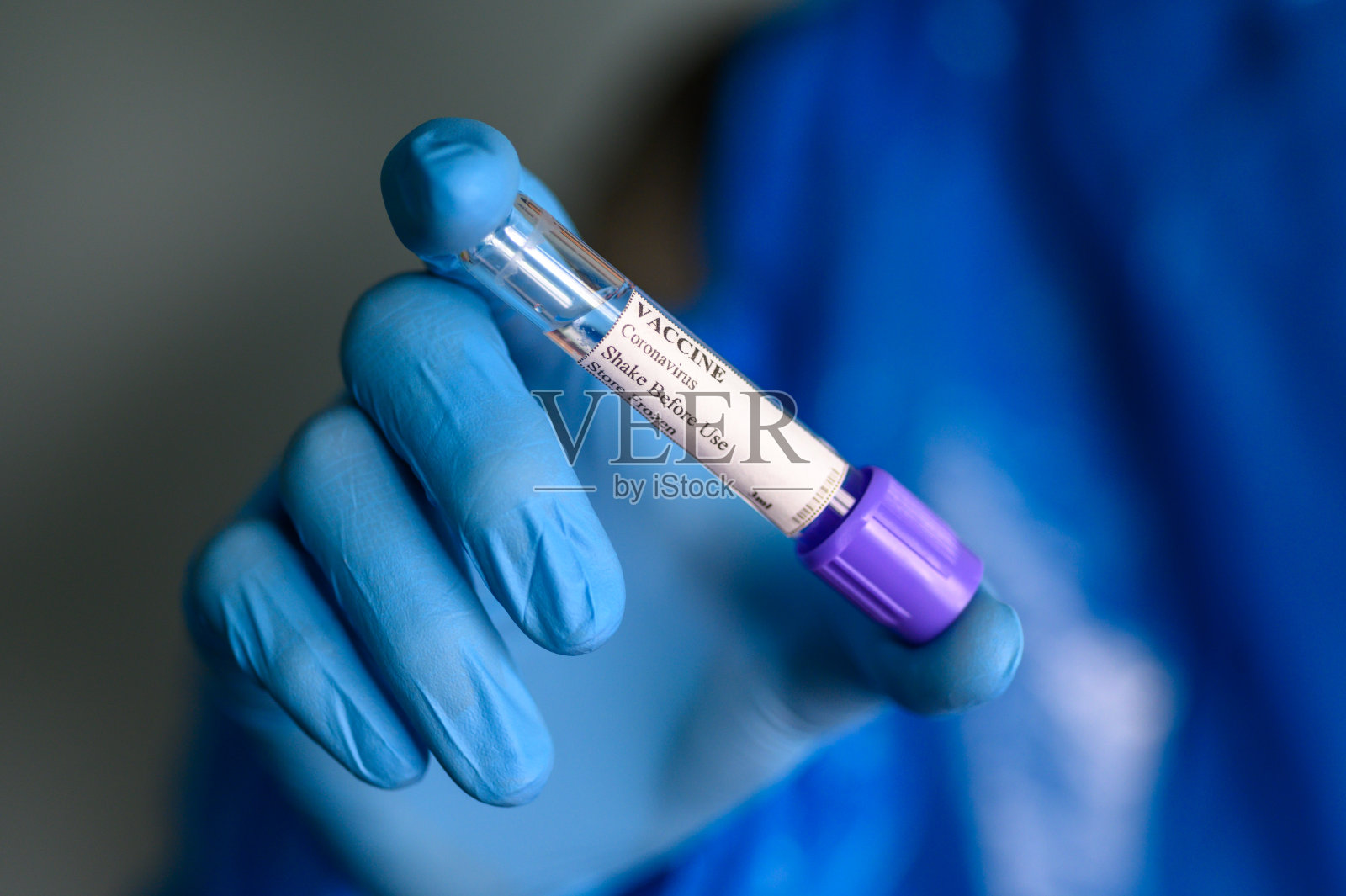 手戴防护手套，将冠状病毒疫苗放在实验室试管中进行Covid-19检测照片摄影图片