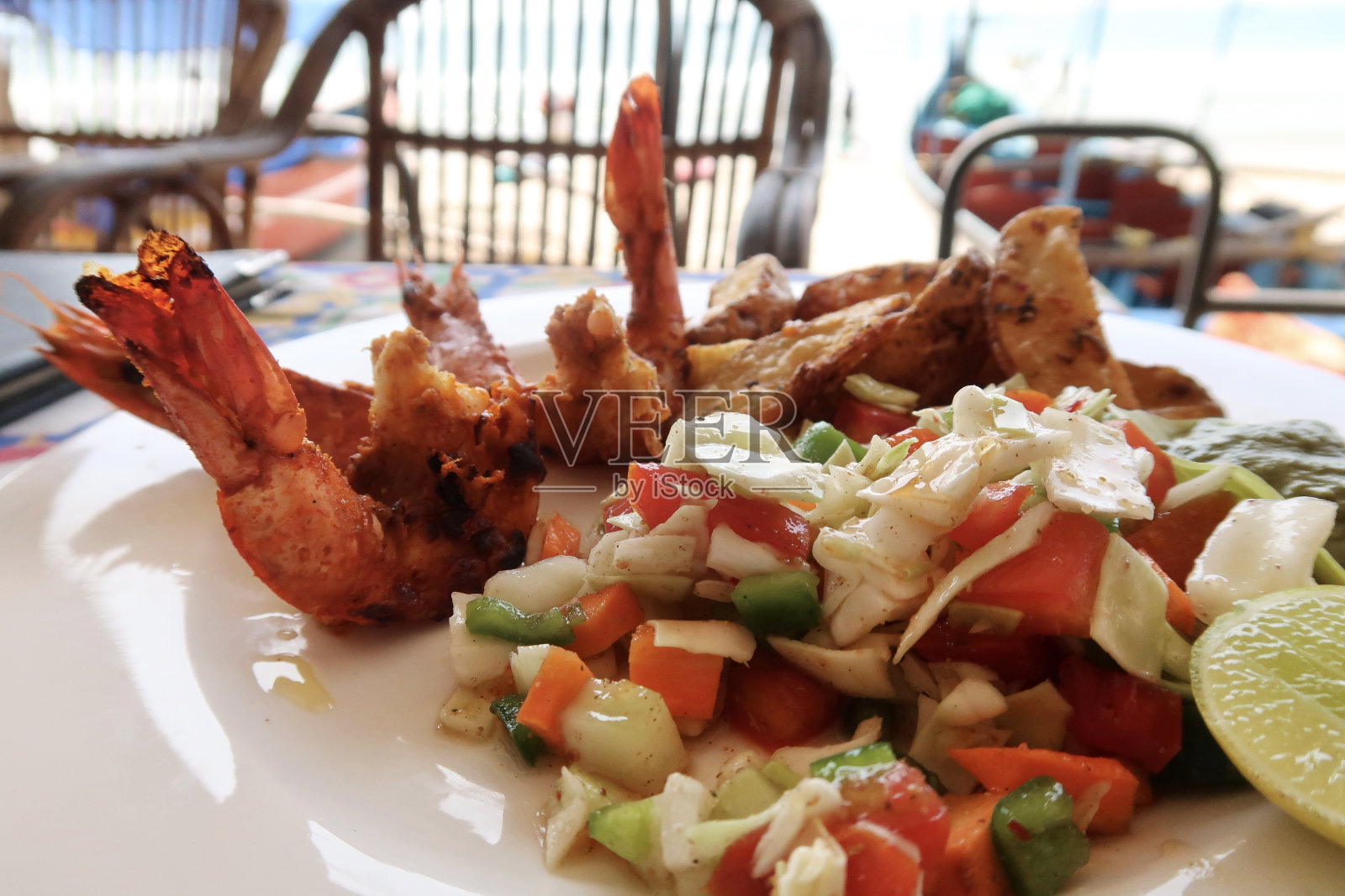 油炸黄油和大蒜大虾配土豆片和混合蔬菜沙拉，柠檬片照片摄影图片