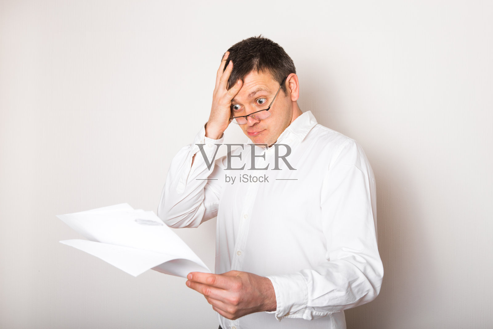 滑稽的白人商人肖像吃惊地打开眼镜看财务报告，坏消息概念照片摄影图片