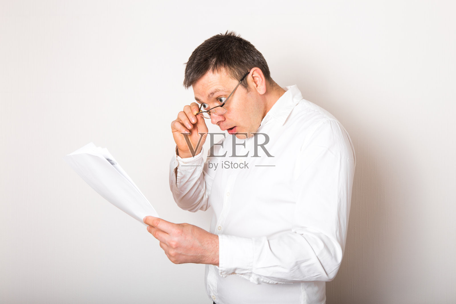 滑稽的白人商人肖像吃惊地打开眼镜看财务报告，坏消息概念照片摄影图片