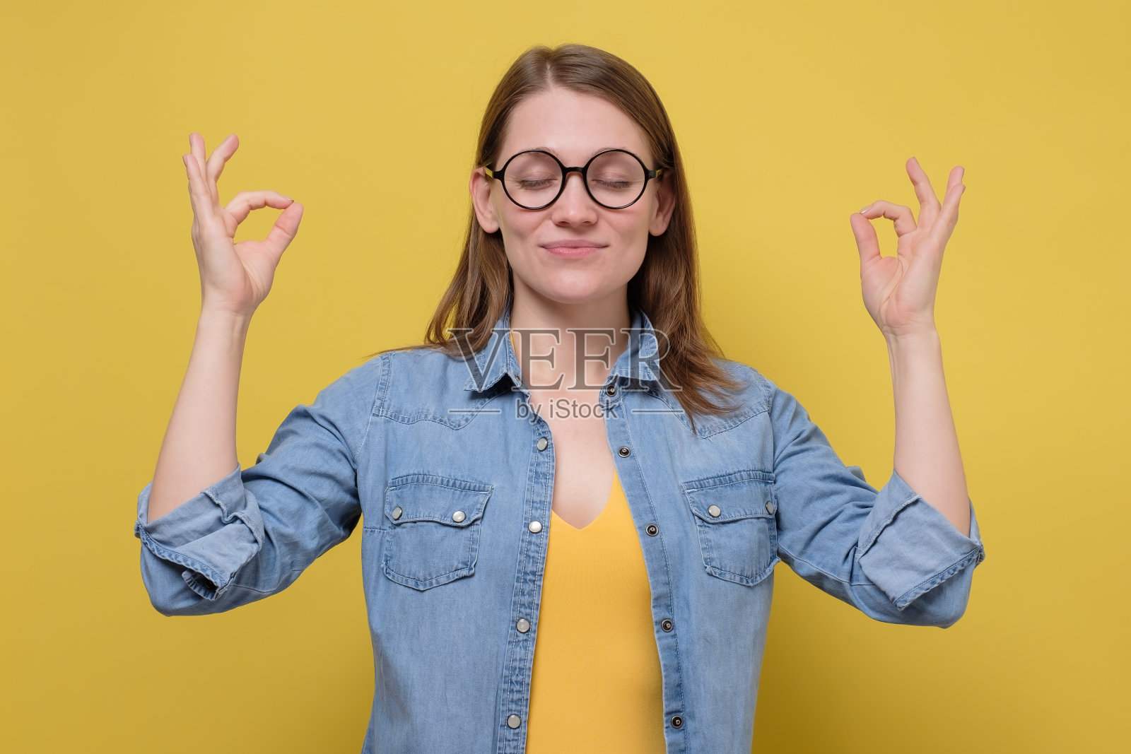 戴眼镜的美女在黄色的墙上沉思照片摄影图片