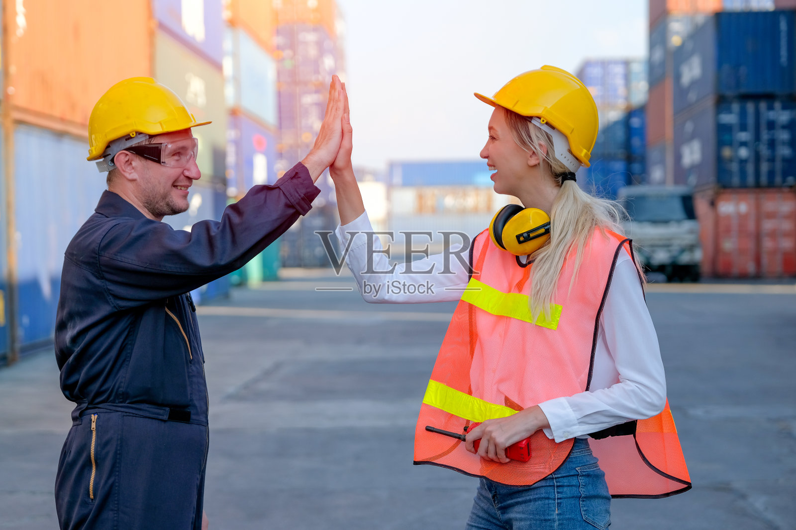 聪明的工人男人和女人一起触摸他们的手，以表达在货物集装箱航运区工作的成功与白昼照片摄影图片