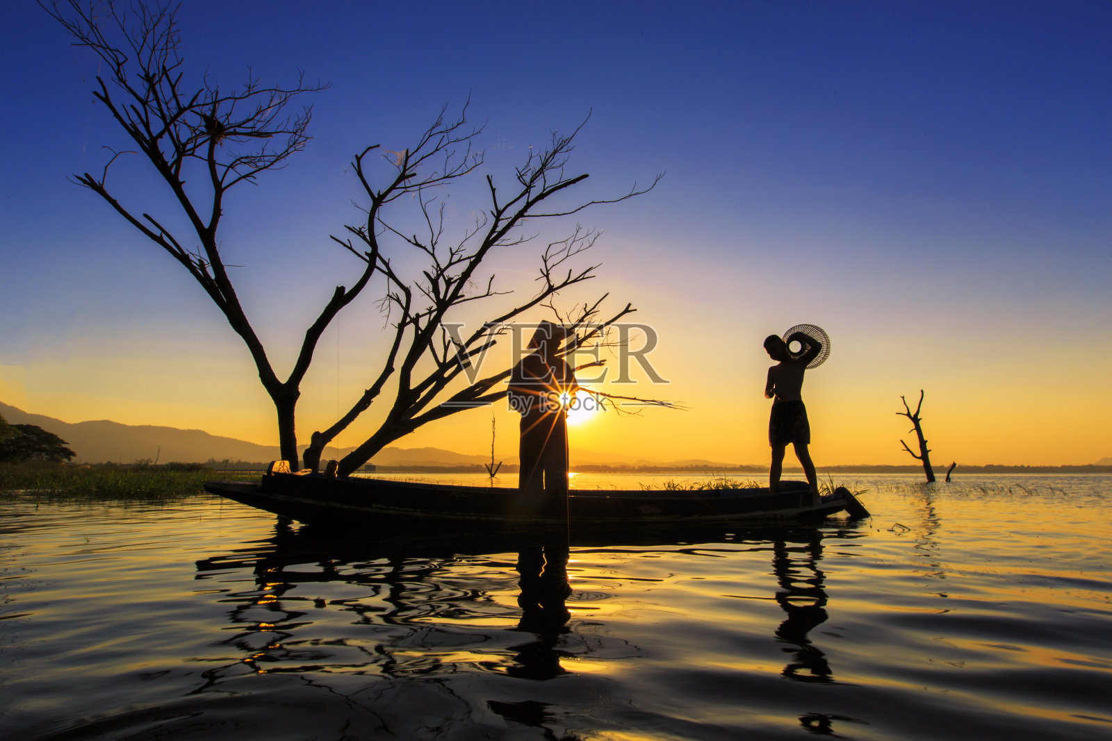 泰国春武里省邦普拉水库的渔民在日出时用渔网捕鱼的剪影。照片摄影图片