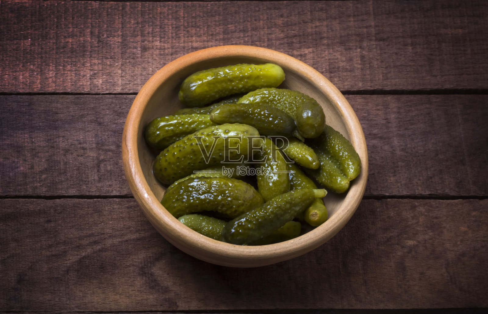 陶土碗里的泡菜在黑暗的乡村背景下，俯视图照片摄影图片