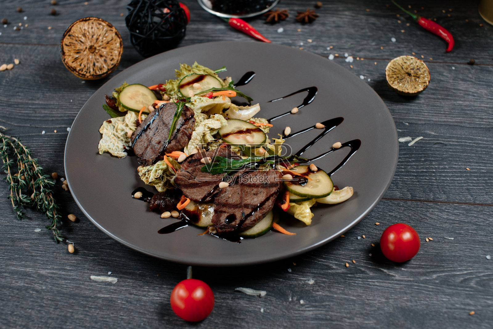 灰色的桌子上有烤肉和新鲜的沙拉。餐馆提供的传统菜肴菜单照片摄影图片