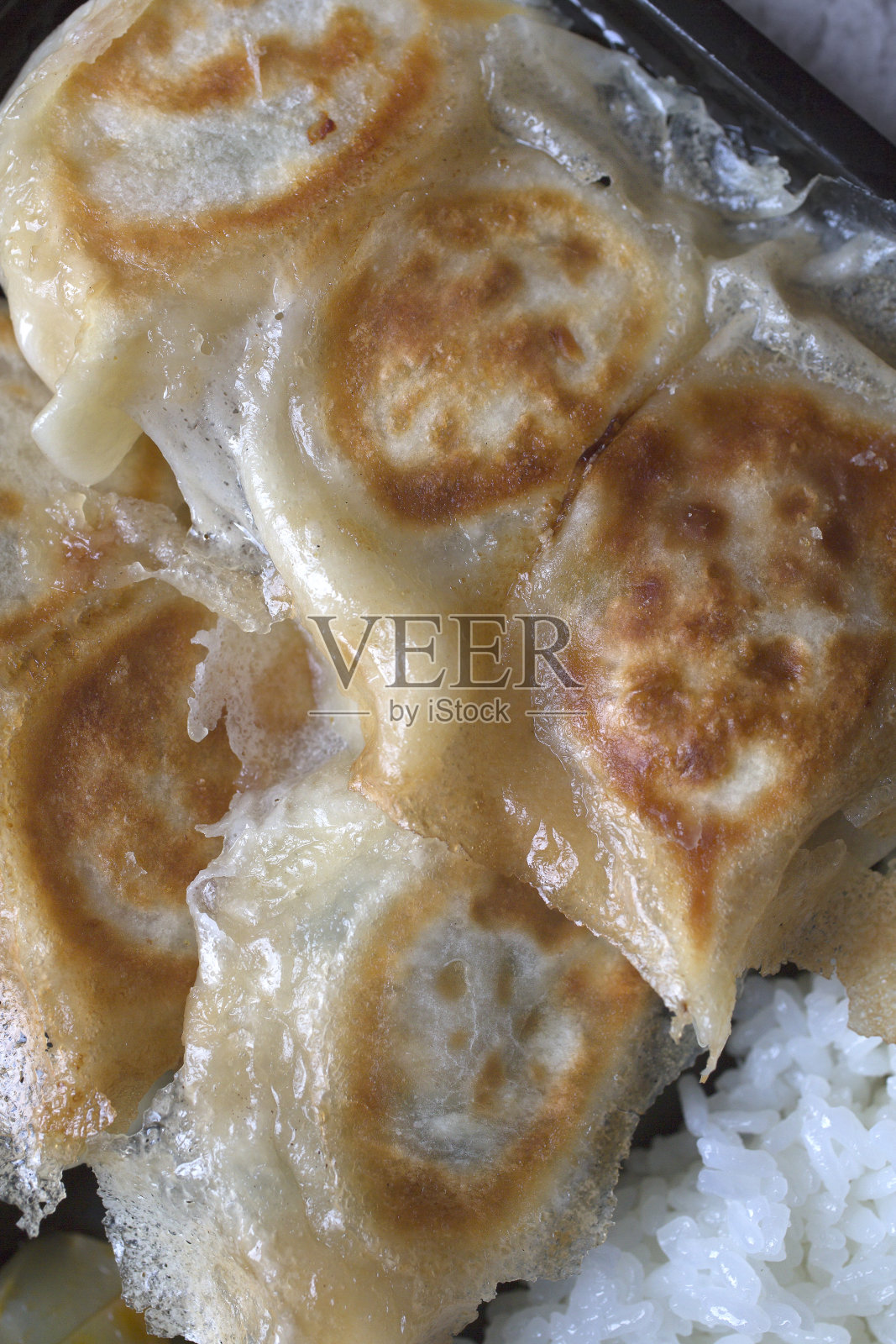 装有饺子的盒饭。酥脆的日式煎饺。照片摄影图片