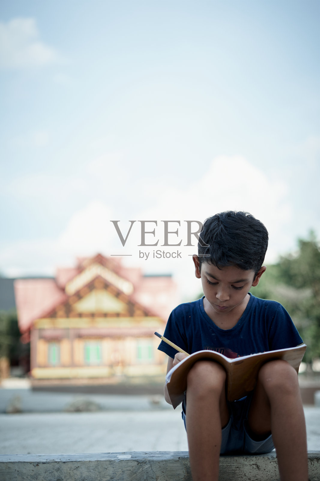 小男孩在家写作和学习，在感染新冠病毒期间在家学习照片摄影图片