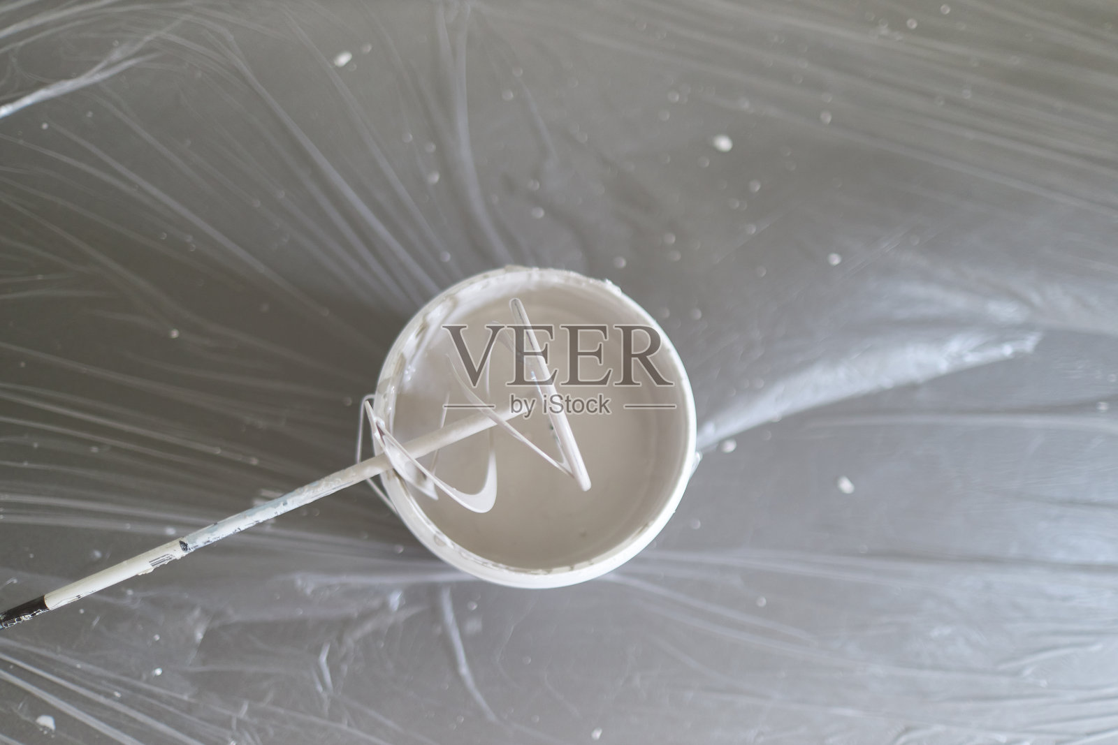 一位中年男子用油漆滚筒、油漆桶、油漆和梯子在家里的墙上油漆照片摄影图片