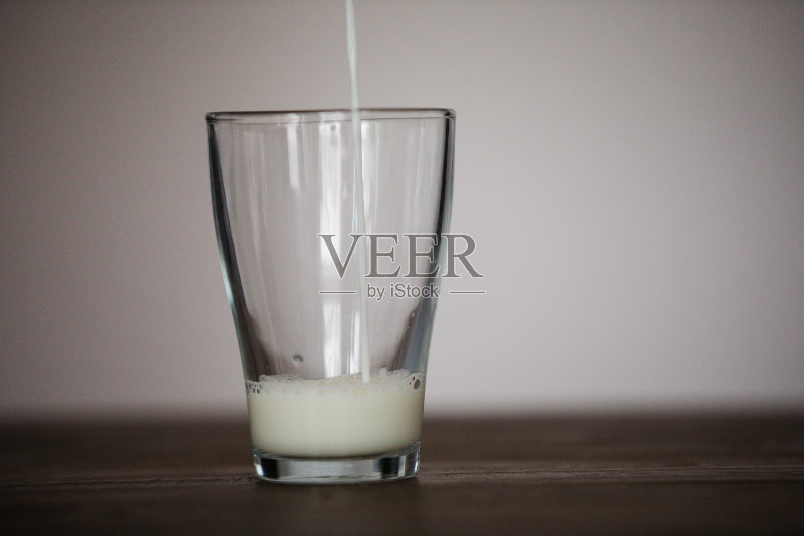 往玻璃杯里倒牛奶照片摄影图片