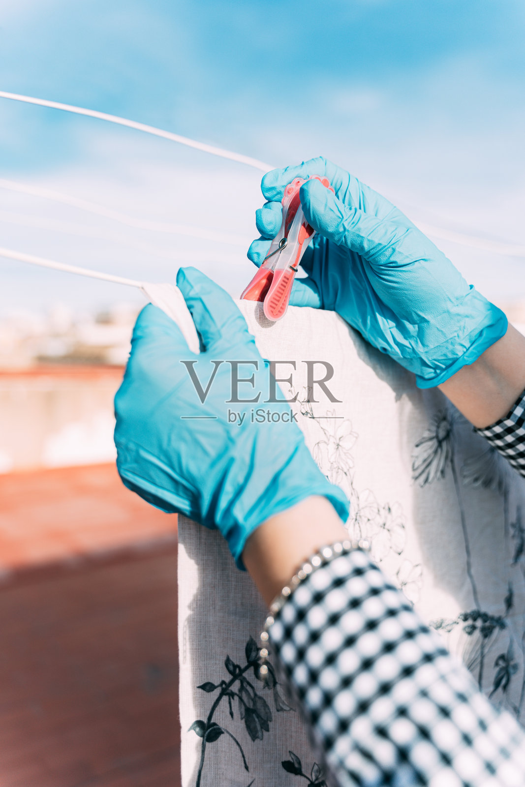 冠状病毒戴着手套的手摆放衣服的特写照片。病毒防护和协议。呆在家里。监禁照片摄影图片