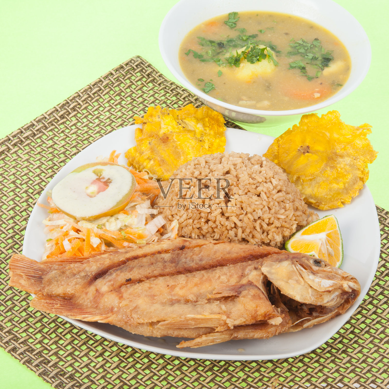 炒鱼——罗非鱼配椰子饭、炒芭蕉、沙拉和汤。照片摄影图片