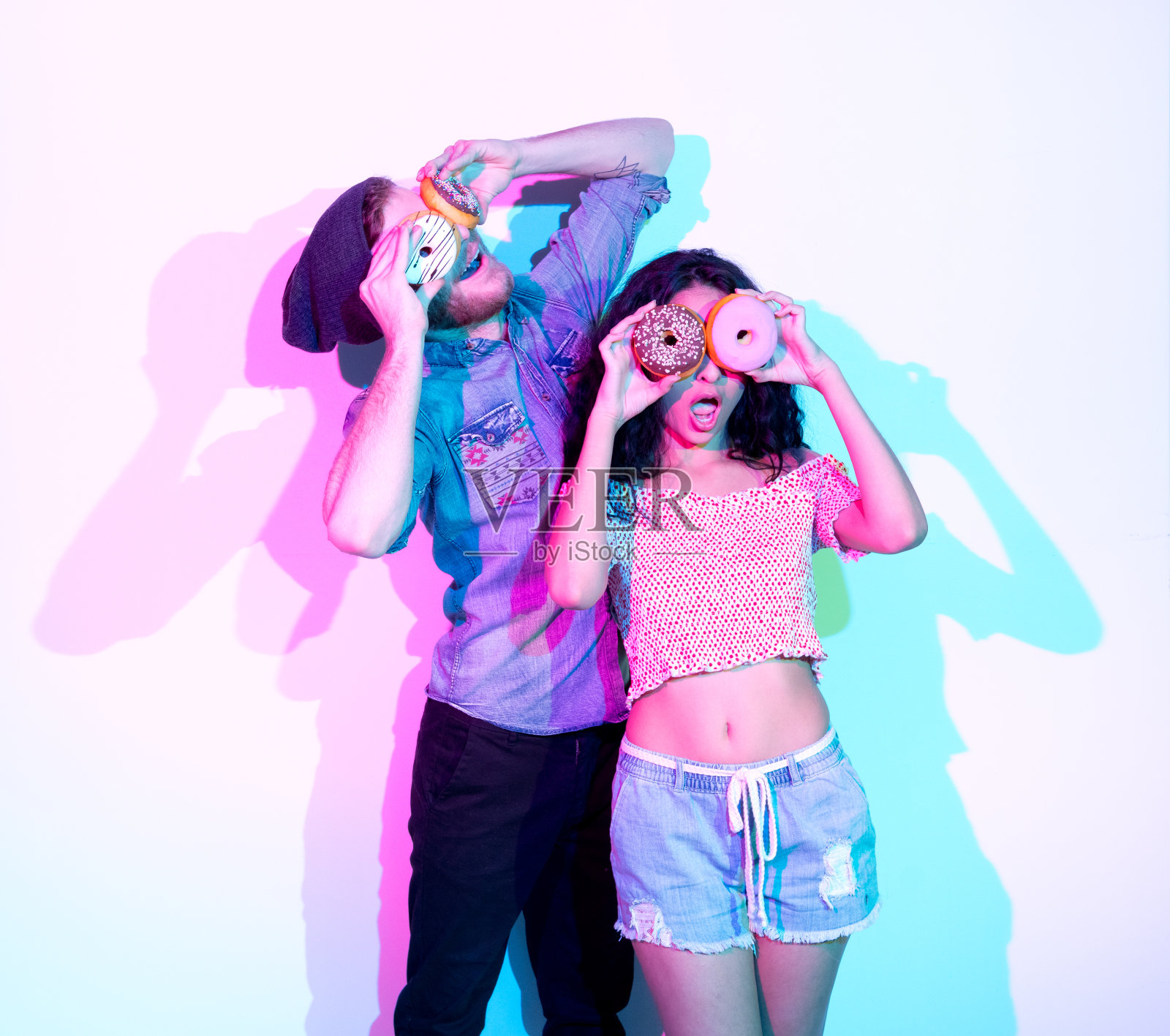 年轻男性潮人穿着纽扣衬衫和拿着甜甜圈照片摄影图片