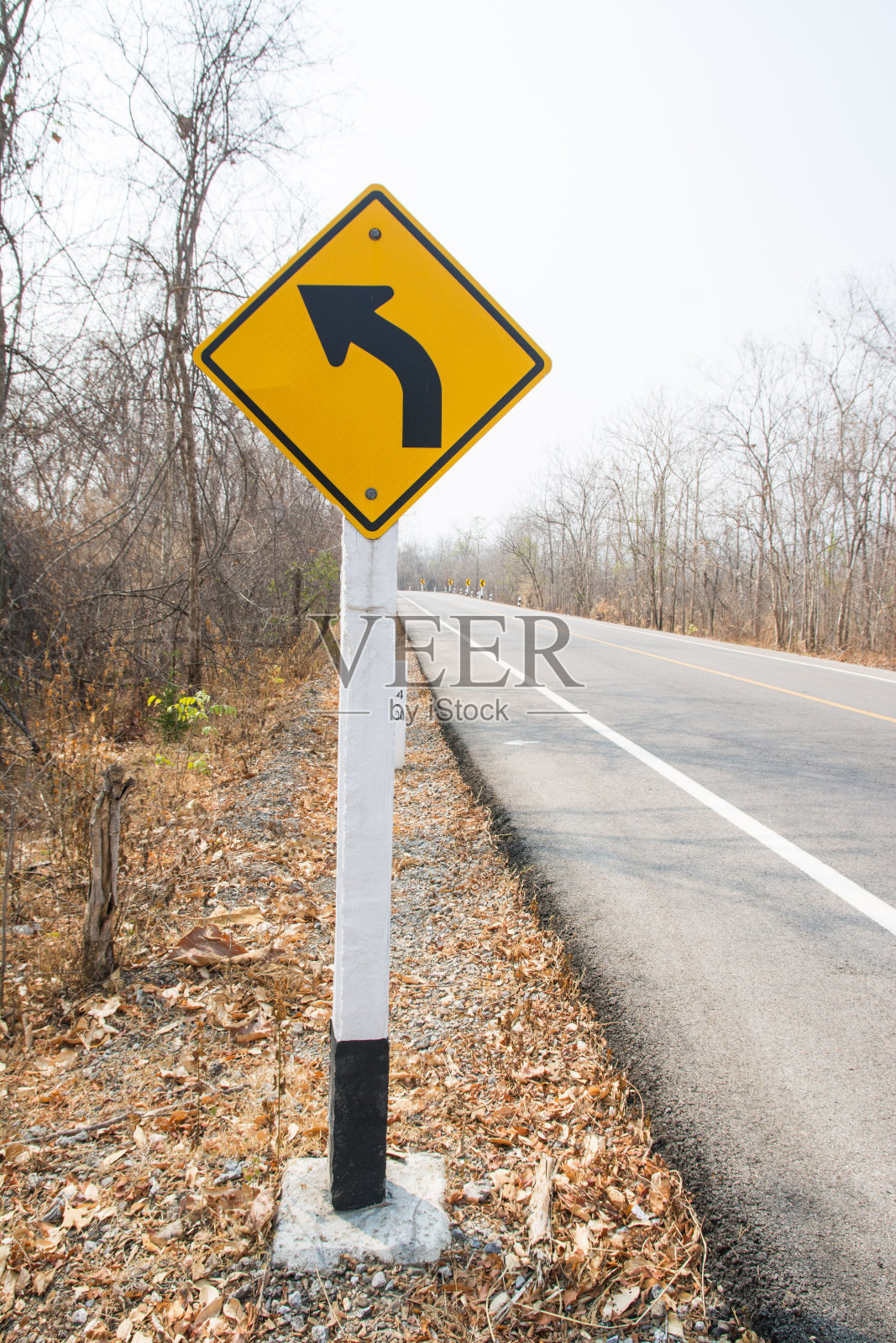 秋天森林里的交通标志和柏油路照片摄影图片