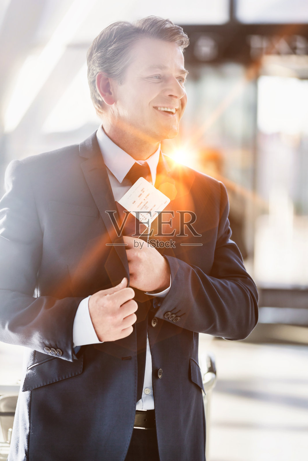 一幅在机场从西装中拿出护照的成熟迷人的商人肖像照片摄影图片