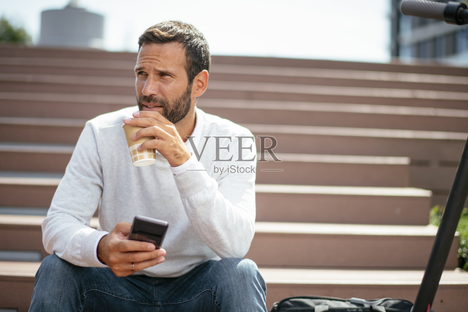 骑着电动车的帅气商人。照片摄影图片