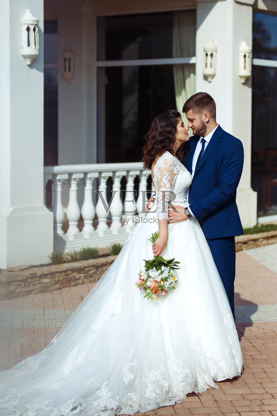 完美的新婚夫妇，新郎摆姿势亲吻。照片摄影图片