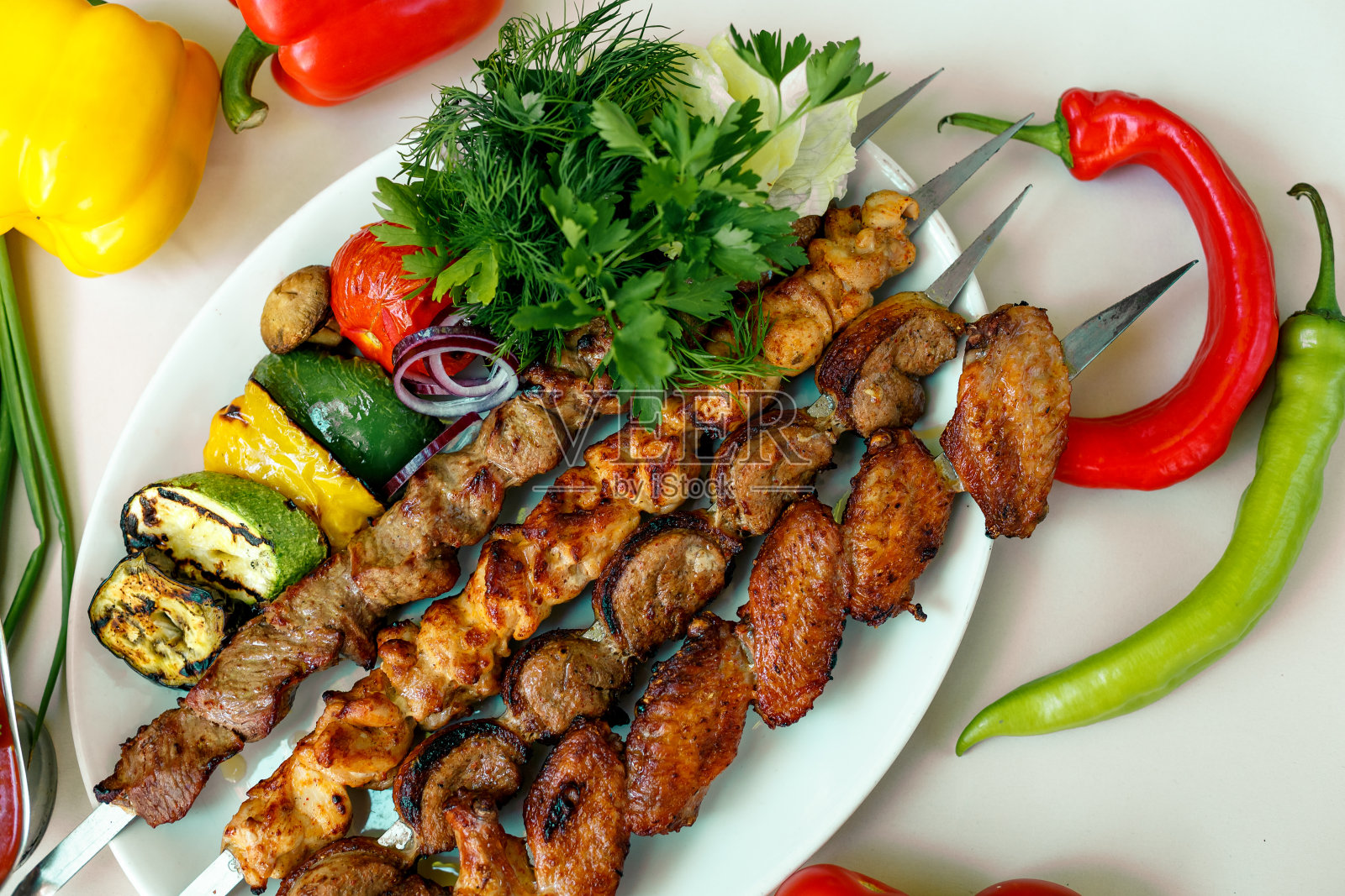 什锦烤肉配烤蔬菜，腌洋葱，香草和辣酱照片摄影图片