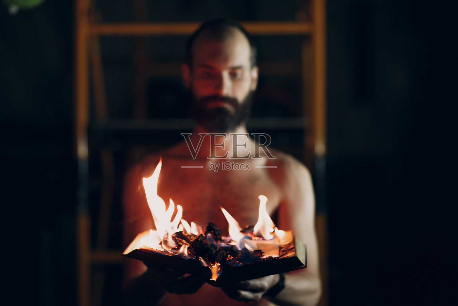 人的手中握着燃烧的书。照片摄影图片