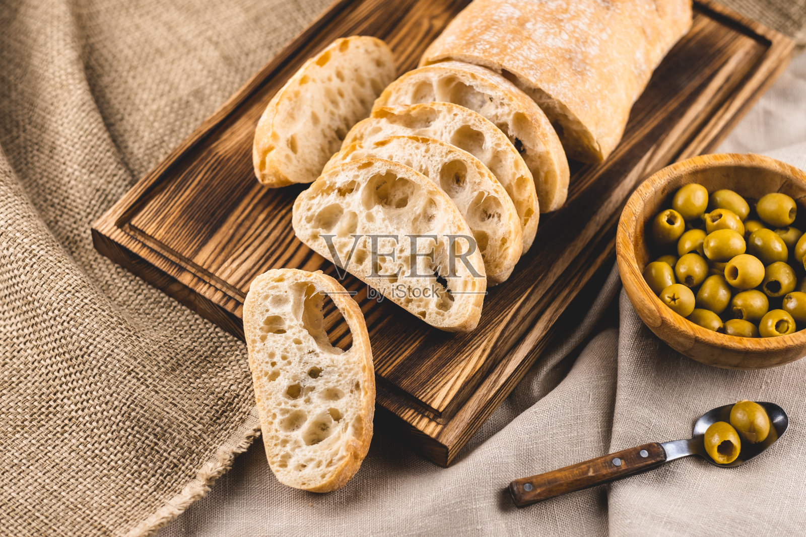 新鲜意大利脆皮意大利面包片和橄榄。照片摄影图片
