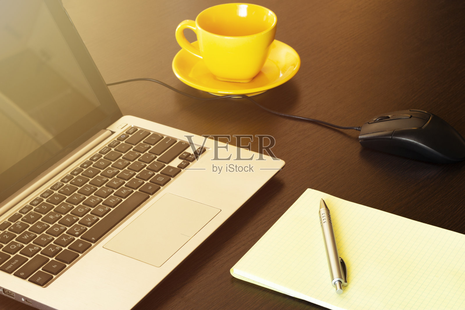 带咖啡杯的笔记本和带笔的笔记本放在旧木桌上。照片摄影图片