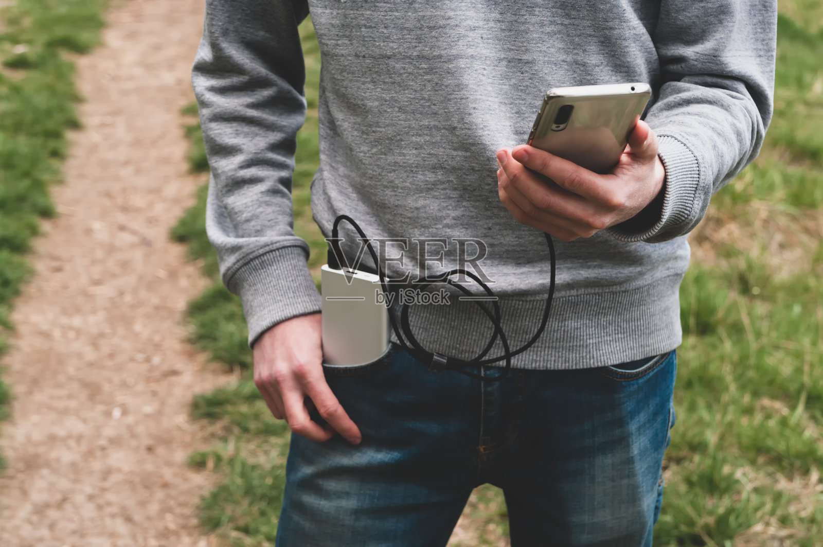 一名年轻人在户外用手机充电。现代技术的概念。有选择性的重点。照片摄影图片